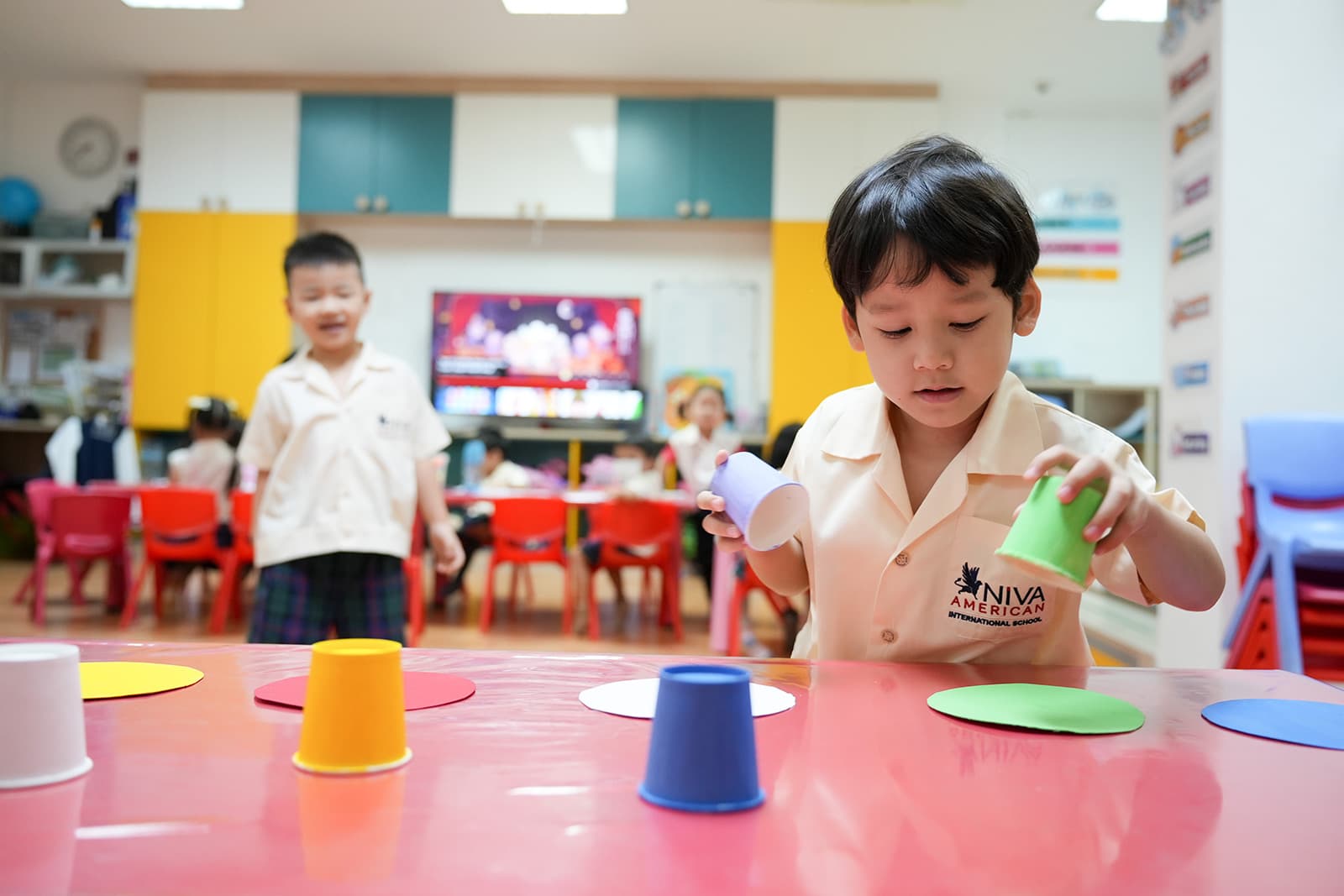 A NIVA kindergarten student engaging in a play-based learning task, a color matching game.
