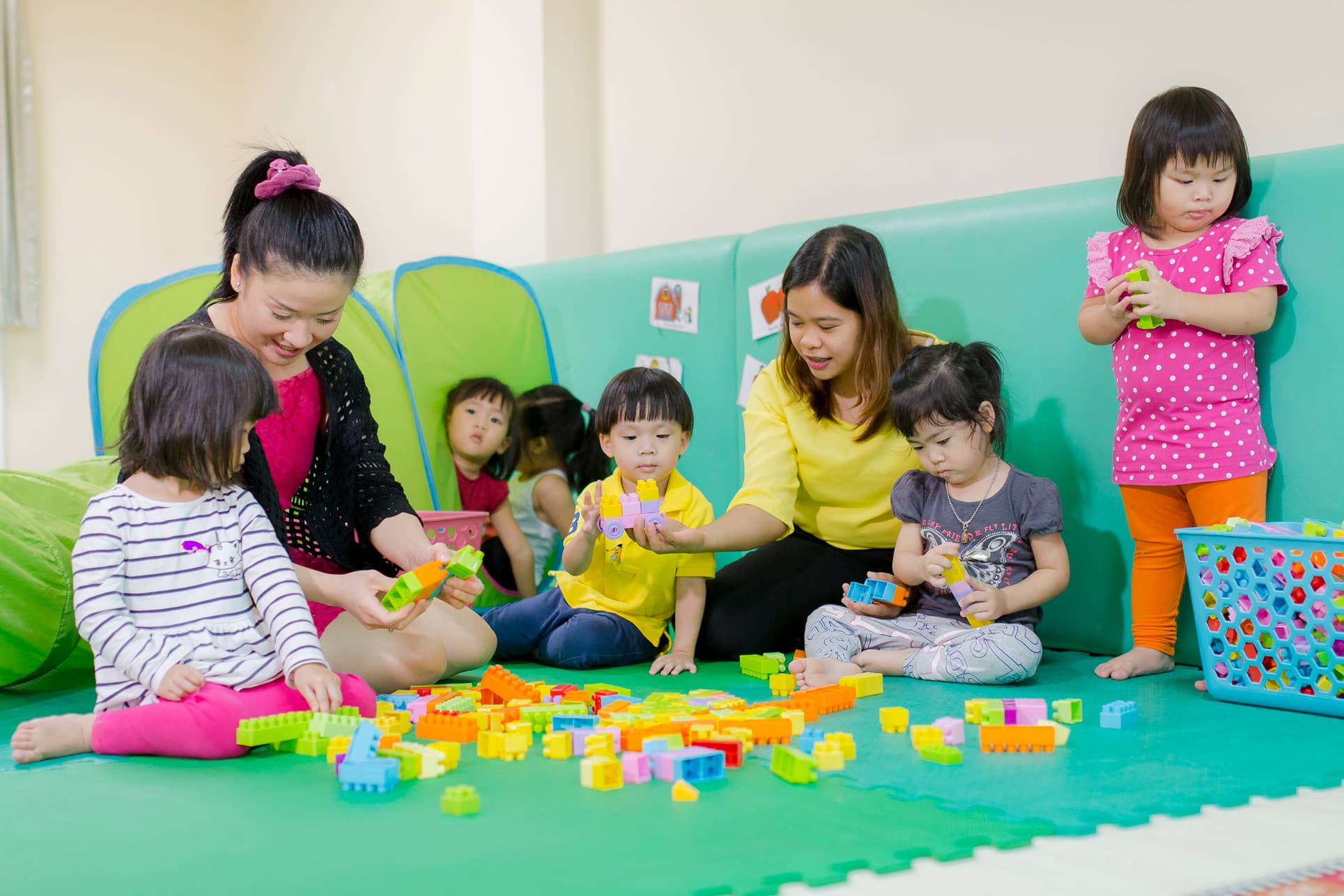 Nursery teachers and students playing together