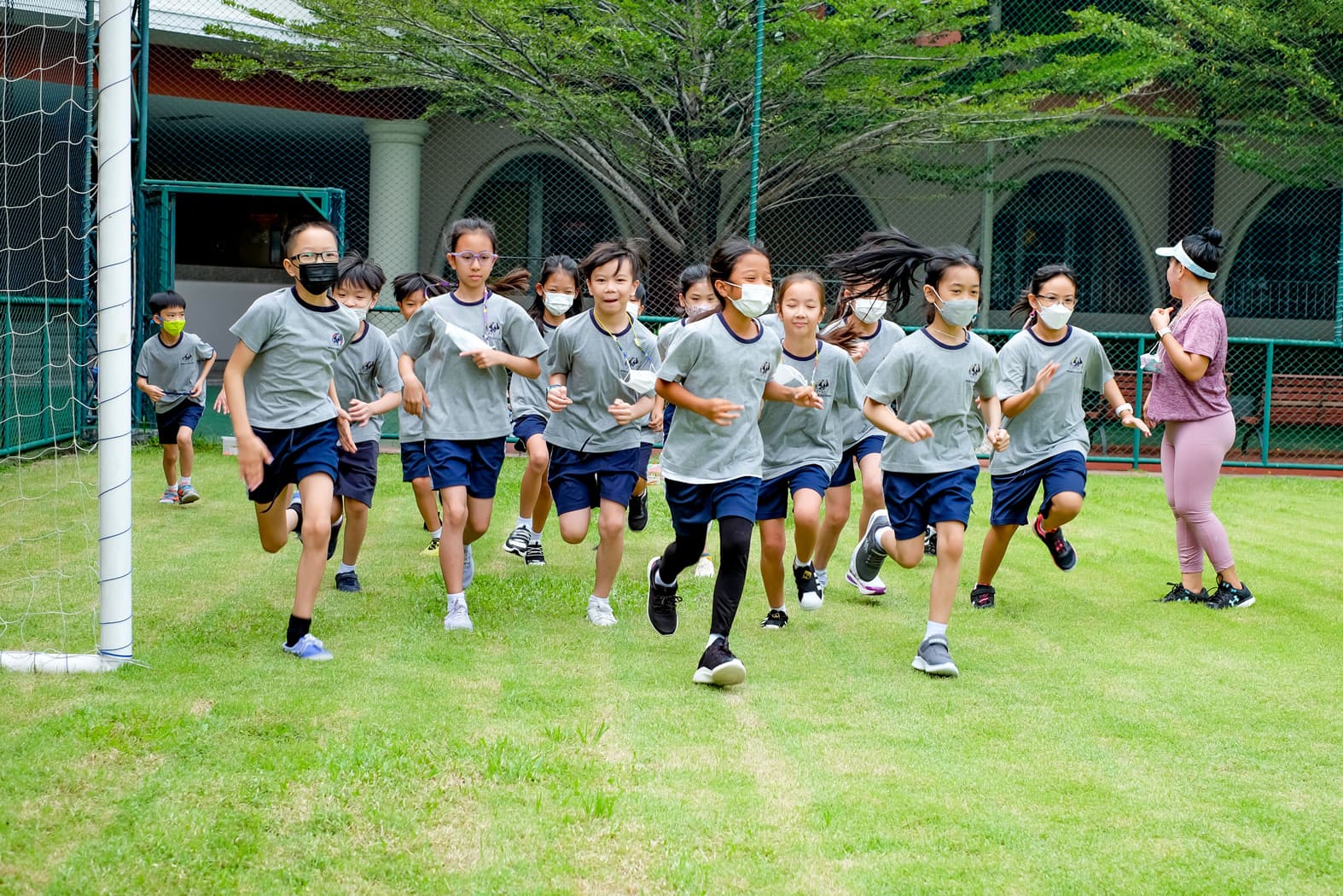 NIVA Multipurpose Field - Students warming up for PE class by running