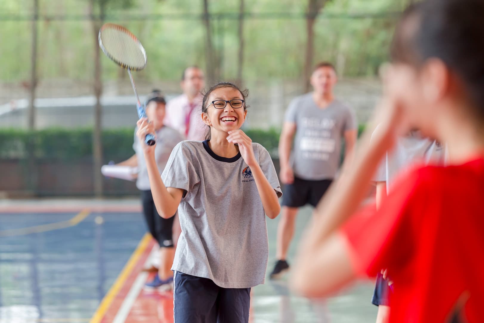 High school girl laughing while playing badminton
