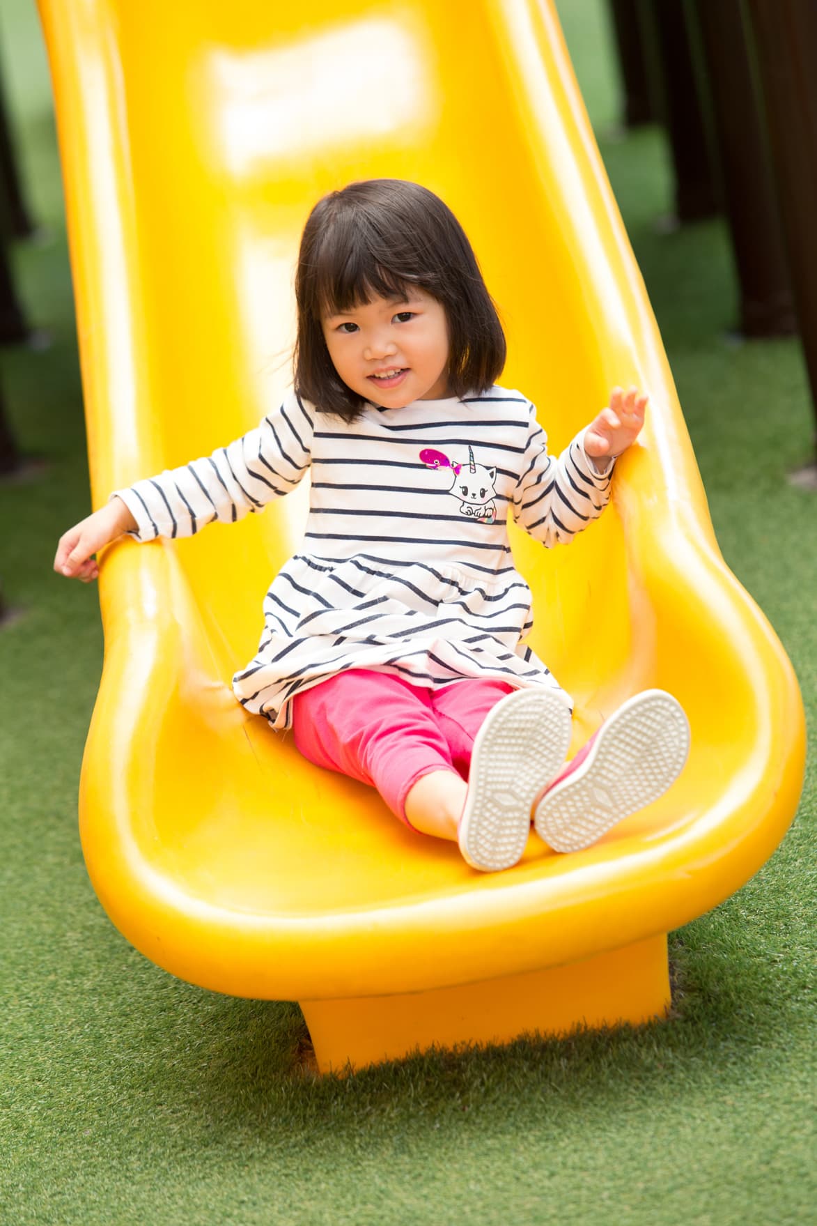 Vertical nursery girl sliding down the slider