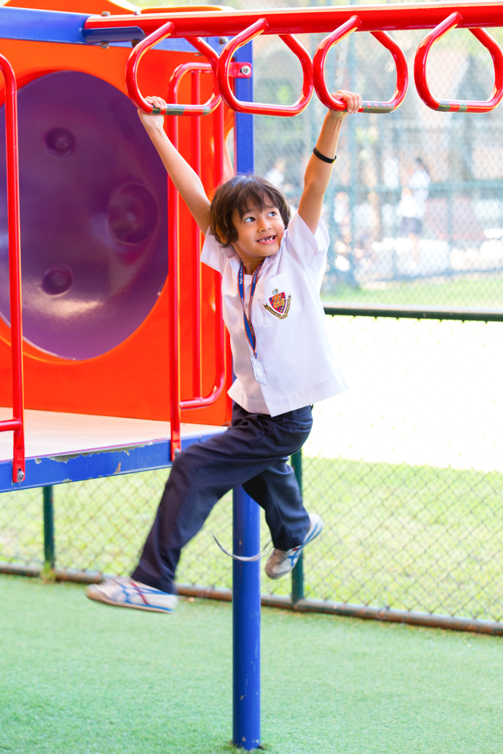 Child hanging from playground rings