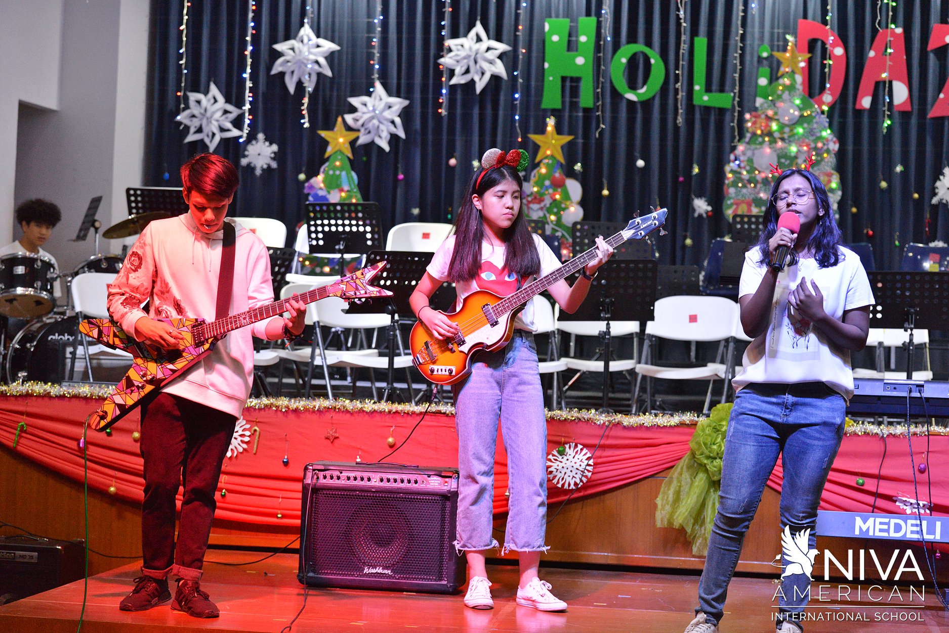 Student band playing guitars and singing on stage