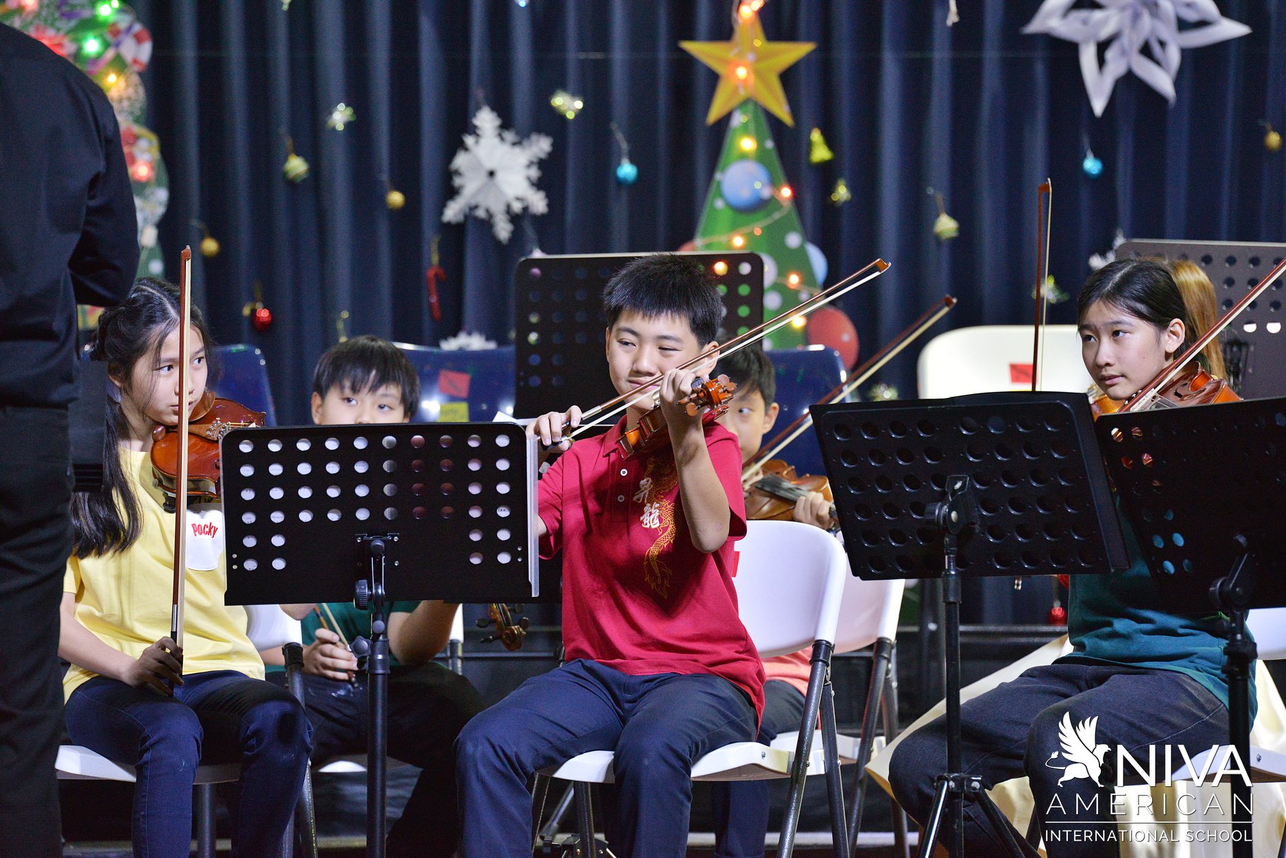 Student band performing with brass instruments on stage