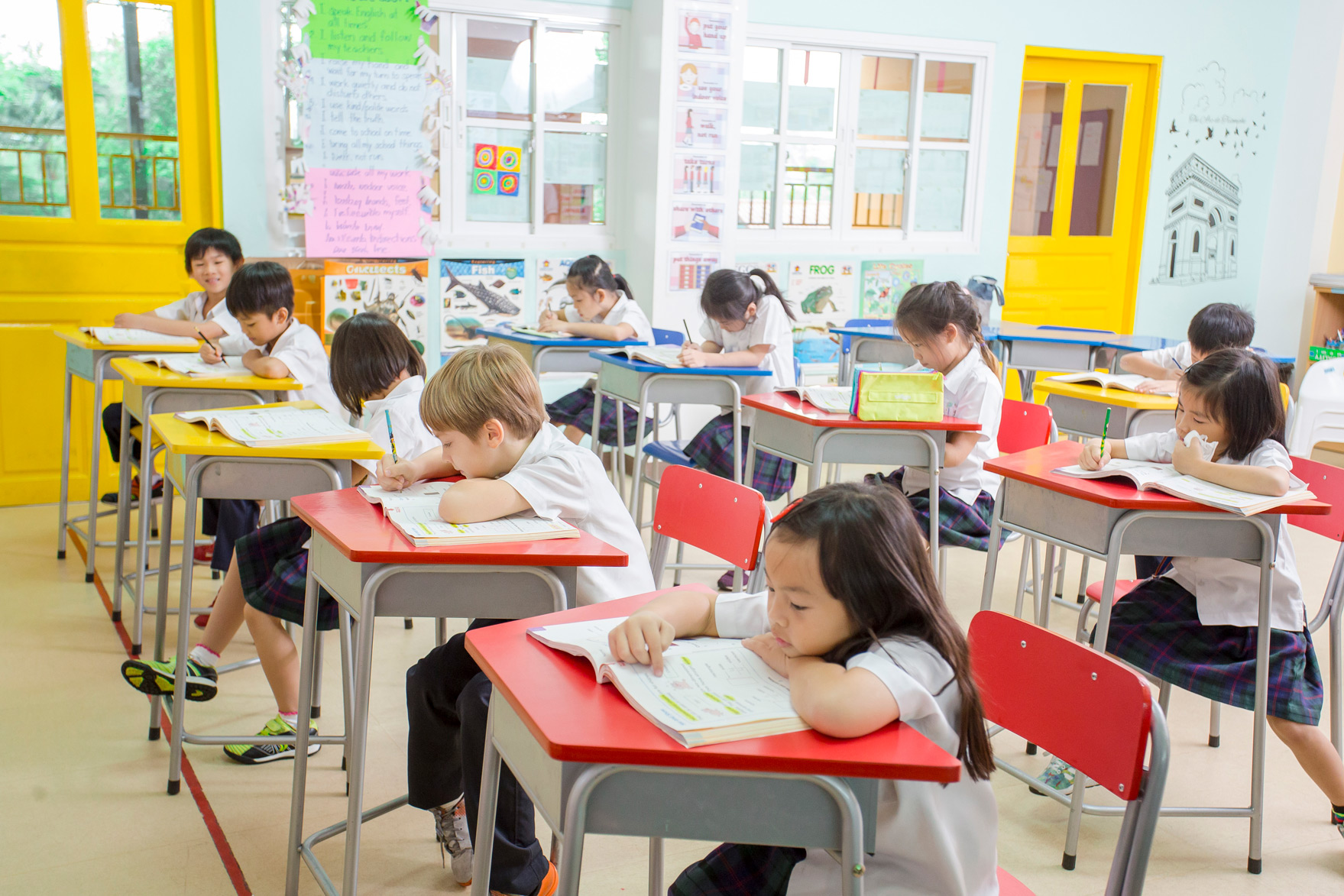 Classroom with students working at rows of colorful desks