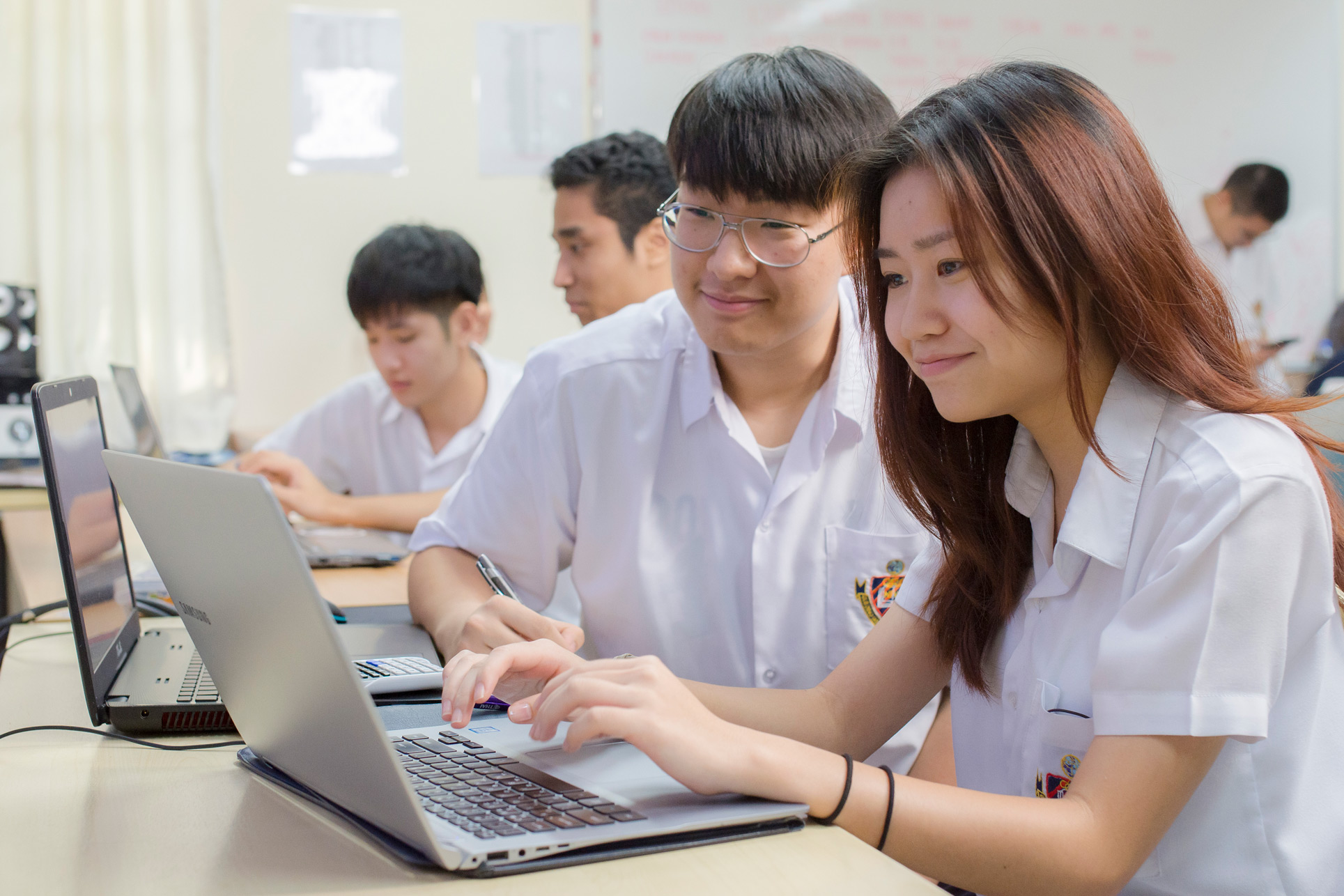 Students working together on a laptop in class