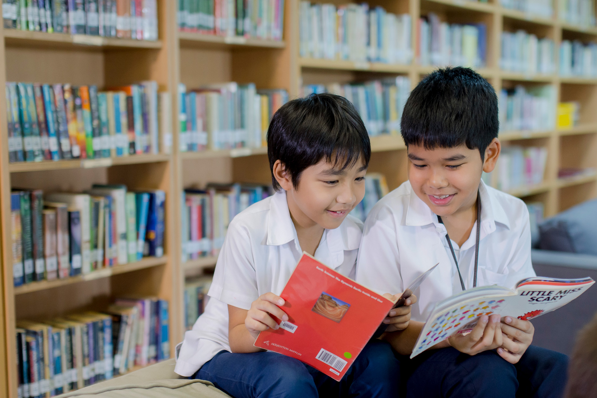 นักเรียนชายสองคนอ่านหนังสือในห้องสมุด